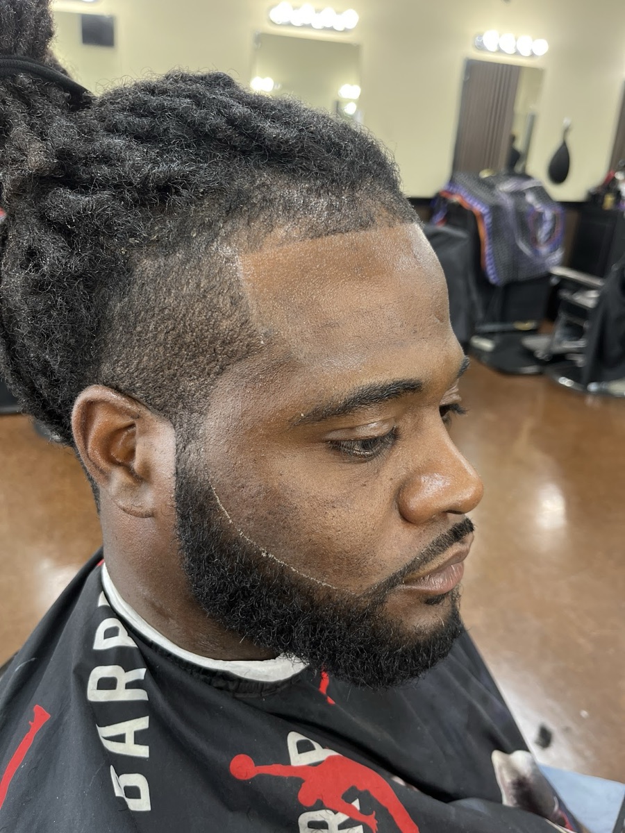 Locs up top blended into a low fade with a clean beard line