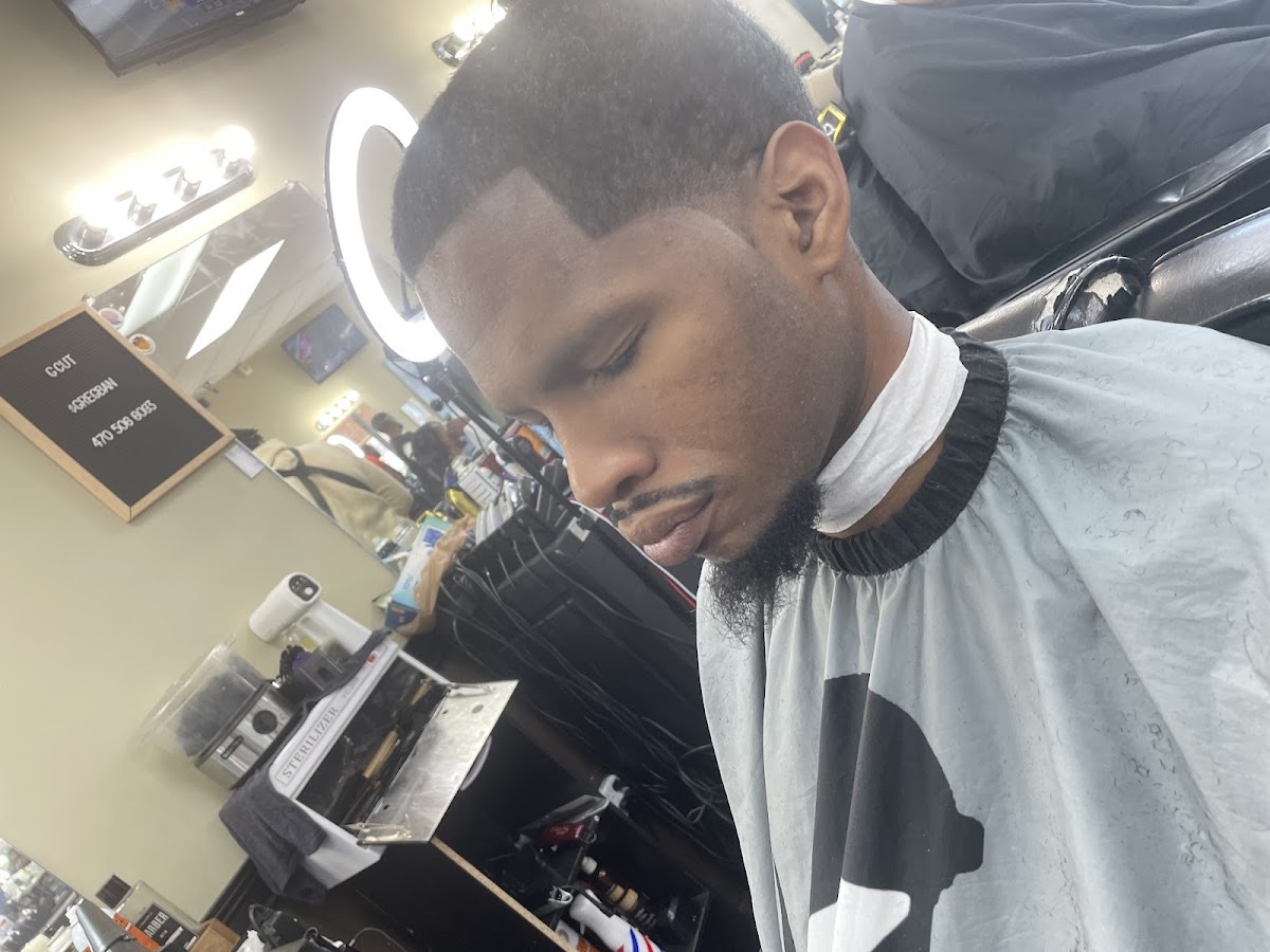Crisp skin fade, line-up and beard shape-up, side profile in the chair